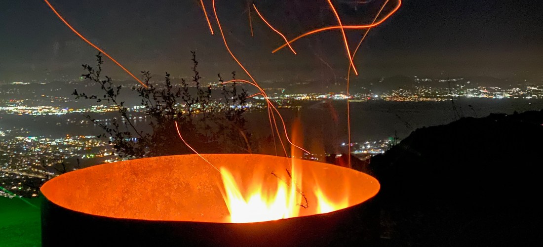 fire pit at night with embers flying out of it