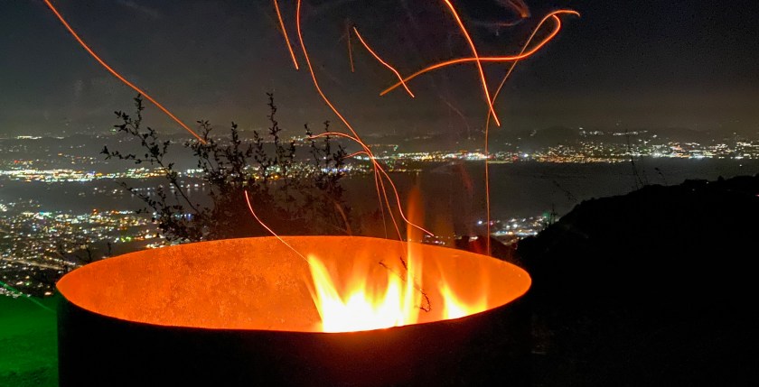 fire pit at night with embers flying out of it